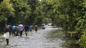 People wade across a waterlogged street in a flood-affected area, in Alleppey.(PTI) People wade across a waterlogged street in a flood-affected area, in Alleppey.(PTI)