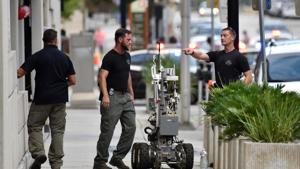 Bomb squad police prepare a robot to enter a parking garage a block away from the scene of a multiple shooting at the Jacksonville Landing on Sunday.(AP) Bomb squad police prepare a robot to enter a parking garage a block away from the scene of a multiple shooting at the Jacksonville Landing on Sunday.(AP)