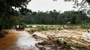 An earth-mover clears the sludge from a road in the flood-hit Madapur village of Kadagu district, Karnataka on August 21.(PTI photo) An earth-mover clears the sludge from a road in the flood-hit Madapur village of Kadagu district, Karnataka on August 21.(PTI photo)