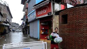 A shopkeeper carries goods down a flooded road in Srinagar after heavy rainfall.(Representative Image/AFP File Photo) A shopkeeper carries goods down a flooded road in Srinagar after heavy rainfall.(Representative Image/AFP File Photo)