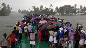 Volunteers use umbrellas to protect from rain as they cross Pampa river to reach to flood-affected areas to clean houses and public places following floods in Kuttanad in Alappuzha district of Kerala.(Reuters File Photo) Volunteers use umbrellas to protect from rain as they cross Pampa river to reach to flood-affected areas to clean houses and public places following floods in Kuttanad in Alappuzha district of Kerala.(Reuters File Photo)
