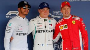 Mercedes' Valtteri Bottas (C) after qualifying in pole position with teammate Lewis Hamilton (L), who qualified second and Ferrari's Sebastian Vettel, who qualified third.(REUTERS) Mercedes' Valtteri Bottas (C) after qualifying in pole position with teammate Lewis Hamilton (L), who qualified second and Ferrari's Sebastian Vettel, who qualified third.(REUTERS)