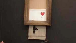 Banksy's painting "Girl with Red Balloon" is seen shredded after its sale at Sotheby auction in London, Britain October 5, 2018 in this still image taken from a video obtained from social media on October 6, 2018.(INSTAGRAM/@PIERREKOUKJIAN/INSTAGRAM/@SINCEFINEART via REUTERS) Banksy's painting "Girl with Red Balloon" is seen shredded after its sale at Sotheby auction in London, Britain October 5, 2018 in this still image taken from a video obtained from social media on October 6, 2018.(INSTAGRAM/@PIERREKOUKJIAN/INSTAGRAM/@SINCEFINEART via REUTERS)