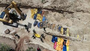 This aerial photo shows Indonesian soldiers burying quake victims in a mass grave in Poboya in Indonesia's Central Sulawesi on October 2, 2018, after an earthquake and tsunami hit the area on September 28.(AFP) This aerial photo shows Indonesian soldiers burying quake victims in a mass grave in Poboya in Indonesia's Central Sulawesi on October 2, 2018, after an earthquake and tsunami hit the area on September 28.(AFP)