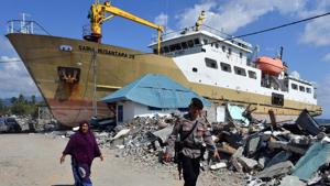 An Indonesian woman and policeman walk beside a stranded ship in Wani, Donggala on October 9, 2018, following the September 28 earthquake and tsunami that hit the area.(AFP Photo) An Indonesian woman and policeman walk beside a stranded ship in Wani, Donggala on October 9, 2018, following the September 28 earthquake and tsunami that hit the area.(AFP Photo)