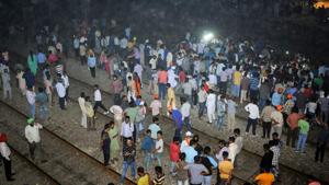People gather near the site of a train accident at Joda Phatak in Amritsar on October 19.(PTI Photo)