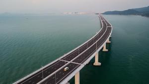 An aerial view shows a van being driven on a section of the Hong Kong-Zhuhai-Macau Bridge (HKZM) in Hong Kong. The world's longest sea-bridge connecting Hong Kong, Macau and mainland China was inaugurated on Tuesday.(AFP Photo) An aerial view shows a van being driven on a section of the Hong Kong-Zhuhai-Macau Bridge (HKZM) in Hong Kong. The world's longest sea-bridge connecting Hong Kong, Macau and mainland China was inaugurated on Tuesday.(AFP Photo)