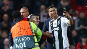 Juventus' Cristiano Ronaldo takes a selfie as stewards apprehend a pitch invader after the match.(REUTERS) Juventus' Cristiano Ronaldo takes a selfie as stewards apprehend a pitch invader after the match.(REUTERS)