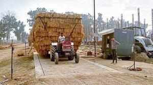 A farmer bringing bales of paddy straw for sale at the plant site on Bajakhana-Jaitu road.(HT Photo) A farmer bringing bales of paddy straw for sale at the plant site on Bajakhana-Jaitu road.(HT Photo)