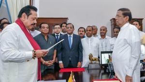 Former Sri Lankan president Mahinda Rajapaksa handing over documents to Sri Lankan President Maithripala Sirisena (R) as Rajapaksa is sworn in as new Prime Minister, in Colombo.(AFP Photo)