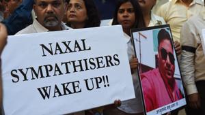 Journalists wearing black arm-bands hold a placard and a photograph of DD cameraman Achyuta Nanda Sahu, who was killed by in a Maoist ambush in Chhattisgarh during a protest meeting to condemn the killing of Achyuta, in Mumbai on November 1, 2018.(AFP) Journalists wearing black arm-bands hold a placard and a photograph of DD cameraman Achyuta Nanda Sahu, who was killed by in a Maoist ambush in Chhattisgarh during a protest meeting to condemn the killing of Achyuta, in Mumbai on November 1, 2018.(AFP)