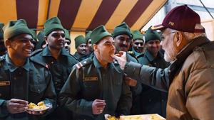 Prime Minister Narendra Modi shares sweets with army personnel.(AFP) Prime Minister Narendra Modi shares sweets with army personnel.(AFP)