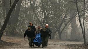 Yuba and Butte County sheriff deputies carry a body bag with a deceased victim of the Camp Fire on November 10 in Paradise, California.(AFP) Yuba and Butte County sheriff deputies carry a body bag with a deceased victim of the Camp Fire on November 10 in Paradise, California.(AFP)