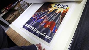 Brian Sylvester, director of the Rochester Public Library, examines original war posters at the library's archive in Rochester, New Hampshire.(AP) Brian Sylvester, director of the Rochester Public Library, examines original war posters at the library's archive in Rochester, New Hampshire.(AP)