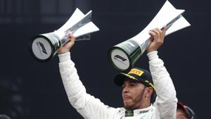 SAO PAULO: Mercedes driver Lewis Hamilton, of Britain, raises trophies after winning the Brazilian Formula One Grand Prix at the Interlagos race track in Sao Paulo.(AP) SAO PAULO: Mercedes driver Lewis Hamilton, of Britain, raises trophies after winning the Brazilian Formula One Grand Prix at the Interlagos race track in Sao Paulo.(AP)