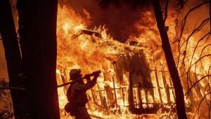 Firefighter Jose Corona sprays water as flames consume from the Camp Fire consume a home in Magalia, Calif, November 9, 2018. (AP Photo/Noah Berger, File)(AP) Firefighter Jose Corona sprays water as flames consume from the Camp Fire consume a home in Magalia, Calif, November 9, 2018. (AP Photo/Noah Berger, File)(AP)