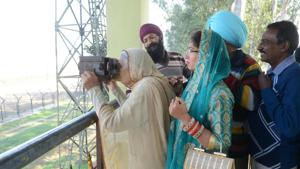 An Indian Sikh devotee looks through binocular towards the Gurdwara Kartarpur Sahib, which is situated in Pakistan, from Indian side at Dera Baba Nanak on the outskirts of Amritsar on November 25, 2018(AFP) An Indian Sikh devotee looks through binocular towards the Gurdwara Kartarpur Sahib, which is situated in Pakistan, from Indian side at Dera Baba Nanak on the outskirts of Amritsar on November 25, 2018(AFP)
