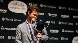 World chess champion Norway's Magnus Carlsen poses with the FIDE world chess championship trophy after beating challenger, US player Fabiano Caruana (not pictured) in the tie-break matches of the 2018 World Chess Championship in London.(AFP) World chess champion Norway's Magnus Carlsen poses with the FIDE world chess championship trophy after beating challenger, US player Fabiano Caruana (not pictured) in the tie-break matches of the 2018 World Chess Championship in London.(AFP)