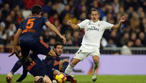 Real Madrid's Lucas Vazquez vies for the ball with three Valencia defenders during their match at the Santiago Bernabeu Stadium.(AP)