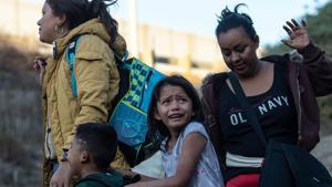 A girl cries as a group of Central American migrants surrender to US Border Patrol agents after jumping over the metal barrier separating Playas de Tijuana in Mexico from the United States.Thousands of Central American migrants, mostly Hondurans, have trekked for over a month in the hopes of reaching the United States.(AFP) A girl cries as a group of Central American migrants surrender to US Border Patrol agents after jumping over the metal barrier separating Playas de Tijuana in Mexico from the United States.Thousands of Central American migrants, mostly Hondurans, have trekked for over a month in the hopes of reaching the United States.(AFP)