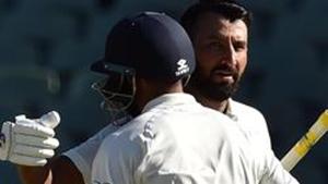 India's batsman Cheteshwar Pujara celebrates his century against Australia with teammate Mohammed Shami (L) during day one of the first cricket Test match at the Adelaide Oval .(AFP)