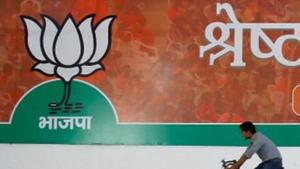 A worker of the BJP rides his bicycle past the party's campaign billboard outside their party headquarters in New Delhi.(REUTERS) A worker of the BJP rides his bicycle past the party's campaign billboard outside their party headquarters in New Delhi.(REUTERS)