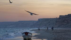 Fishermen stand on the Indian Ocean beach at dusk in the former pirate village of Eyl, in Somalia's semiautonomous northeastern state of Puntland.(AP File photo) Fishermen stand on the Indian Ocean beach at dusk in the former pirate village of Eyl, in Somalia's semiautonomous northeastern state of Puntland.(AP File photo)