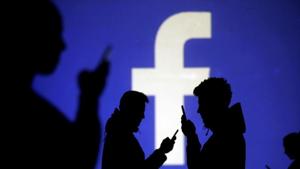 Silhouettes of mobile users are seen next to a screen projection of Facebook logo.(REUTERS) Silhouettes of mobile users are seen next to a screen projection of Facebook logo.(REUTERS)