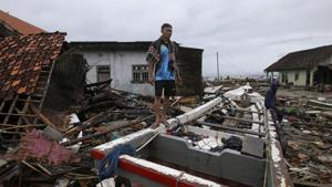 Sumur: A villager stands at a tsunami-ravaged village in Sumur, Indonesia, Tuesday, Dec. 25, 2018. The Christmas holiday was somber with prayers for tsunami victims in the Indonesian region hit by waves that struck without warning Saturday night.(AP) Sumur: A villager stands at a tsunami-ravaged village in Sumur, Indonesia, Tuesday, Dec. 25, 2018. The Christmas holiday was somber with prayers for tsunami victims in the Indonesian region hit by waves that struck without warning Saturday night.(AP)