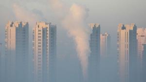A chimney is seen in front of residential buildings during a polluted day in China.(REUTERS) A chimney is seen in front of residential buildings during a polluted day in China.(REUTERS)