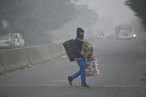 A commuter crosses a road on a cold winter morning, near Kalindi Kunj, in New Delhi, India,(Biplov Bhuyan/HT PHOTO) A commuter crosses a road on a cold winter morning, near Kalindi Kunj, in New Delhi, India,(Biplov Bhuyan/HT PHOTO)