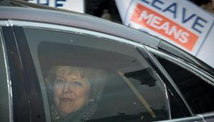Theresa May passes a pro-Brexit demonstrator holding a 'Leave Means Leave' placard on Monday.(Bloomberg) Theresa May passes a pro-Brexit demonstrator holding a 'Leave Means Leave' placard on Monday.(Bloomberg)