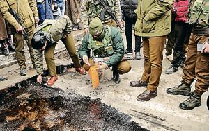 Police officers inspect the site of a grenade explosion, at Lal Chowk, in Srinagar, on Friday.(Waseem Andrabi /HT Photo)