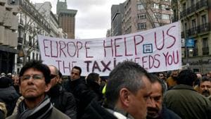 Spanish taxi drivers gather outside the People's Party (PP) headquarters in Madrid to protest amid a strike against VTCs (Tourism Vehicles with Chauffeur).(AFP) Spanish taxi drivers gather outside the People's Party (PP) headquarters in Madrid to protest amid a strike against VTCs (Tourism Vehicles with Chauffeur).(AFP)