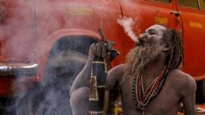 A Naga Sadhu smokes outside his tent ahead of the "Kumbh Mela", in Prayagraj, January 13, 2019. Many sadhus on Thursday promised to quit smoking chillum after call by yoga guru Ramdev.(Reuters) A Naga Sadhu smokes outside his tent ahead of the "Kumbh Mela", in Prayagraj, January 13, 2019. Many sadhus on Thursday promised to quit smoking chillum after call by yoga guru Ramdev.(Reuters)