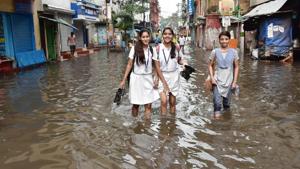 School students crossing the road after water logging in the area due to heavy rain in Kolkata on Thursday.(ANI Photo) School students crossing the road after water logging in the area due to heavy rain in Kolkata on Thursday.(ANI Photo)