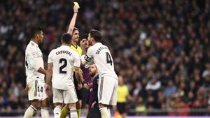 Spanish referee Undiano Mallenco hands a yellow card to Real Madrid's Spanish defender Sergio Ramos during the Spanish league match between Real Madrid CF and FC Barcelona.(AFP) Spanish referee Undiano Mallenco hands a yellow card to Real Madrid's Spanish defender Sergio Ramos during the Spanish league match between Real Madrid CF and FC Barcelona.(AFP)