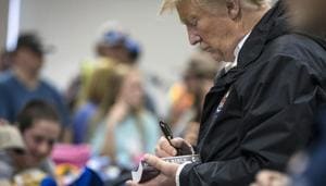 Donald Trump signed several hats and Bibles, including one for a 12-year-old boy, an action which drew applause from people who came to see the President.(NYT) Donald Trump signed several hats and Bibles, including one for a 12-year-old boy, an action which drew applause from people who came to see the President.(NYT)