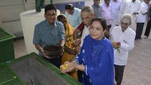 A devotee drops flowers into the composting machine at Bhajan Samaj temple in Ghatkopar.(HT)