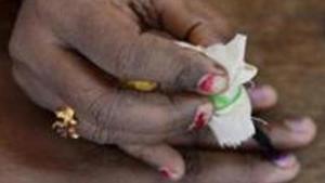 TOPSHOT - An Indian election official (R) puts indeliable ink on the finger of a voter before she casts her ballot in the Karnataka Legislative Assembly Elections at a polling station in Bangalore on May 12, 2018. Voting in a key Indian state opened May 12 amid dirty tricks claims by the two leading parties after nearly 10,000 voting cards were seized by election authorities. The opposition Congress party, which has dominated India's politics in the seven decades since independence, is fighting to retain control of its last major state, Karnataka, amid a fierce onslaught by Prime Minister Narendra Modi's ruling Hindu nationalist party. / AFP PHOTO / MANJUNATH KIRAN(AFP) TOPSHOT - An Indian election official (R) puts indeliable ink on the finger of a voter before she casts her ballot in the Karnataka Legislative Assembly Elections at a polling station in Bangalore on May 12, 2018. Voting in a key Indian state opened May 12 amid dirty tricks claims by the two leading parties after nearly 10,000 voting cards were seized by election authorities. The opposition Congress party, which has dominated India's politics in the seven decades since independence, is fighting to retain control of its last major state, Karnataka, amid a fierce onslaught by Prime Minister Narendra Modi's ruling Hindu nationalist party. / AFP PHOTO / MANJUNATH KIRAN(AFP)