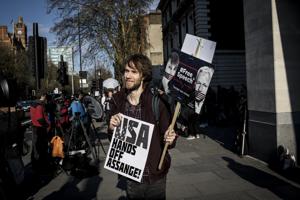 A supporter of WikiLeaks founder Julian Assange holds a sign that reads "USA Hands Off Assange!" during a protest outside the Westminster Magistrates' Court in London, U.K.(Bloomberg) A supporter of WikiLeaks founder Julian Assange holds a sign that reads "USA Hands Off Assange!" during a protest outside the Westminster Magistrates' Court in London, U.K.(Bloomberg)