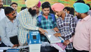 Indian electoral officials demonstrate how to use an Electronic Voting Machine (EVM) and Voter-Verified Paper Audit Trail (VVPAT) to passengers during a voter awareness programme ahead of the upcoming Indian general election at the railway station in Amritsar on April 18, 2019. Image for representation.(AFP file photo)