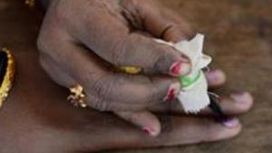 TOPSHOT - An Indian election official (R) puts indeliable ink on the finger of a voter before she casts her ballot in the Karnataka Legislative Assembly Elections at a polling station in Bangalore on May 12, 2018. Voting in a key Indian state opened May 12 amid dirty tricks claims by the two leading parties after nearly 10,000 voting cards were seized by election authorities. The opposition Congress party, which has dominated India's politics in the seven decades since independence, is fighting to retain control of its last major state, Karnataka, amid a fierce onslaught by Prime Minister Narendra Modi's ruling Hindu nationalist party. / AFP PHOTO / MANJUNATH KIRAN(AFP)