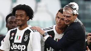 Juventus' Italian coach Massimiliano Allegri (R) embraces Juventus' Portuguese forward Cristiano Ronaldo, both with their head covered in foam, after Juventus secured its 8th consecutive league title.(AFP) Juventus' Italian coach Massimiliano Allegri (R) embraces Juventus' Portuguese forward Cristiano Ronaldo, both with their head covered in foam, after Juventus secured its 8th consecutive league title.(AFP)
