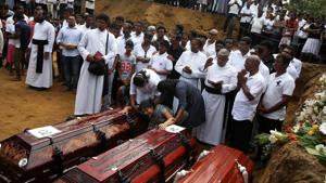 A woman next to coffins during a mass burial of victims, two days after a string of suicide bomb attacks on churches and luxury hotels across the island on Easter Sunday, at a cemetery near St. Sebastian Church in Negombo, Sri Lanka April 23(REUTERS) A woman next to coffins during a mass burial of victims, two days after a string of suicide bomb attacks on churches and luxury hotels across the island on Easter Sunday, at a cemetery near St. Sebastian Church in Negombo, Sri Lanka April 23(REUTERS)
