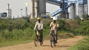 Men ride their bicycles in front of the Bhushan Steel plant in Odisha.(Reuters file) Men ride their bicycles in front of the Bhushan Steel plant in Odisha.(Reuters file)