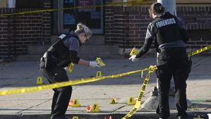 Baltimore police forensics officers place evidence markers next to bullet casings while investigating the scene of a shooting in Baltimore on Sunday, April 28, 2019.(AP) Baltimore police forensics officers place evidence markers next to bullet casings while investigating the scene of a shooting in Baltimore on Sunday, April 28, 2019.(AP)