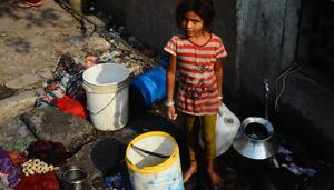 At a press conference, Ramesh Bagwe, Congress city unit president, and Mohan Joshi, Pune Lok Sabha candidate, blamed Bapat for the water issue . (In pic) A girl looks on as she fills buckets with water near a slum in Vishrantwadi.(Shankar Narayan/HT PHOTO)