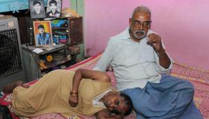 Chandrakeshwar Prasad with his wife in their house in Bihar’s Siwan. The couple’s three sons (photos in the background) were murdered allegedly at the behest of Mhd Shahabuddin whose wife is the RJD candidate from this Lok Sabha seat.(AP Dube/ HT Photo)