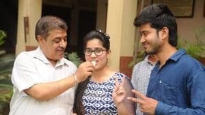 Satish Soni father of Muskan Soni, one of the 3 toppers of PSEB 12th exam, offering sweets to his daughter at Nakodar.(Pardeep Pandit/HT photo) Satish Soni father of Muskan Soni, one of the 3 toppers of PSEB 12th exam, offering sweets to his daughter at Nakodar.(Pardeep Pandit/HT photo)